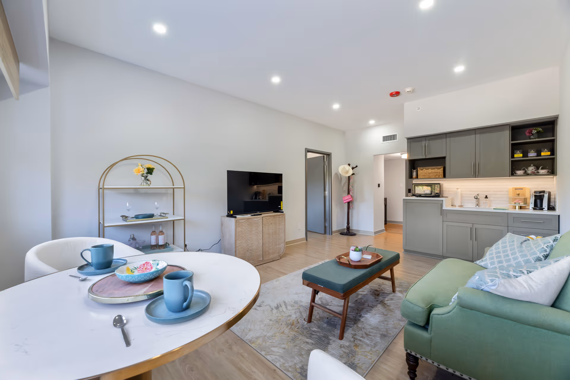 Spacious living area with sofa, dining table, coffee table, and a kitchenette.