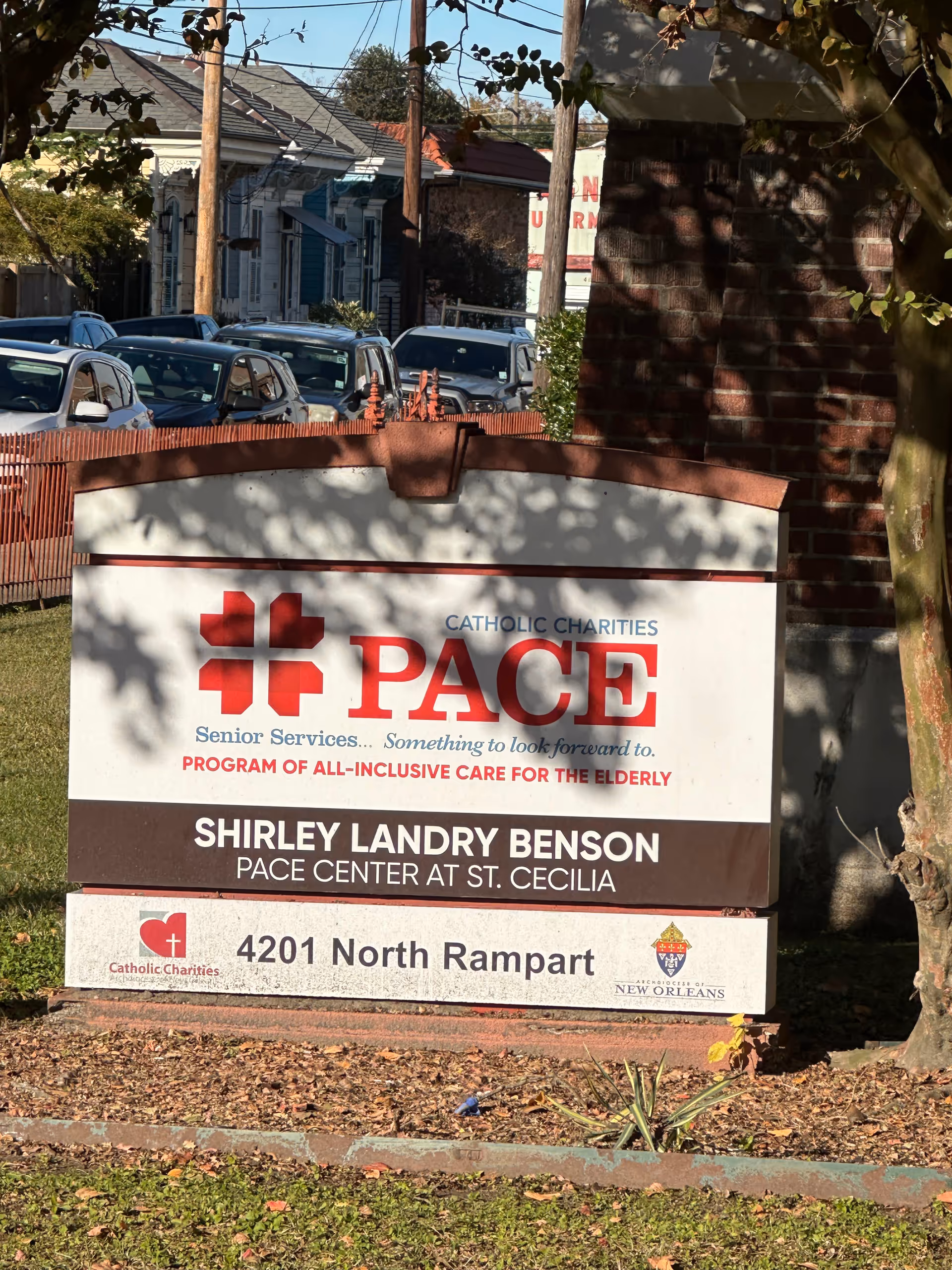 Exterior view of a PACE Center sign with parked cars in background.