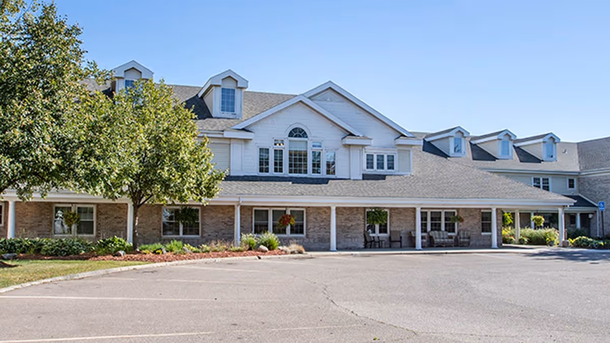 Exterior view of Brookdale Utica senior living facility with a covered front entry and parking