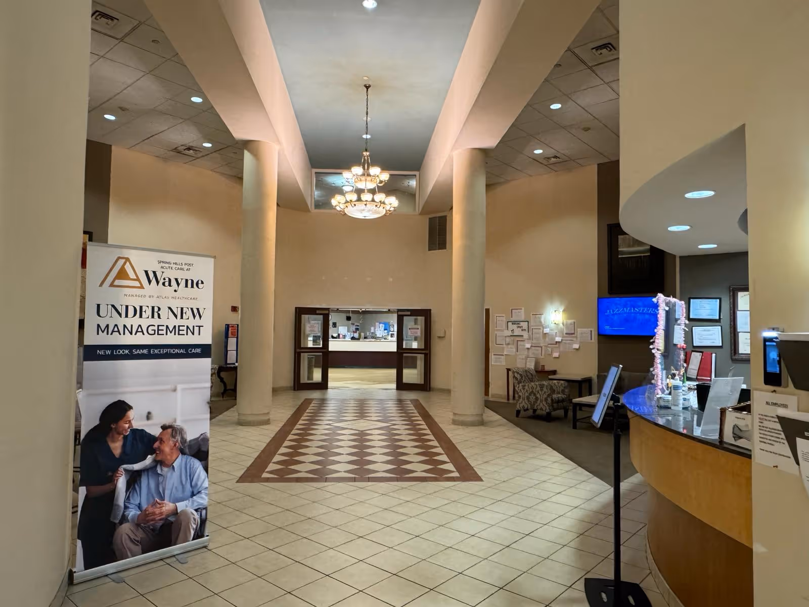 Lobby of Atrium Post Acute Care of Wayne with a reception desk and chandelier.