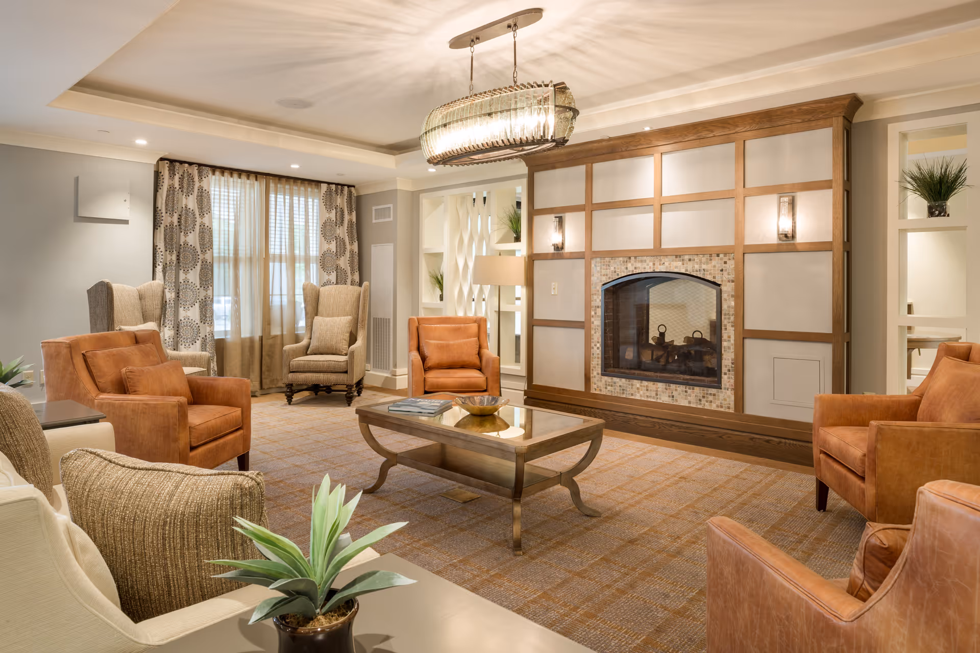 Cozy senior living lounge with a tile fireplace and multiple chairs.