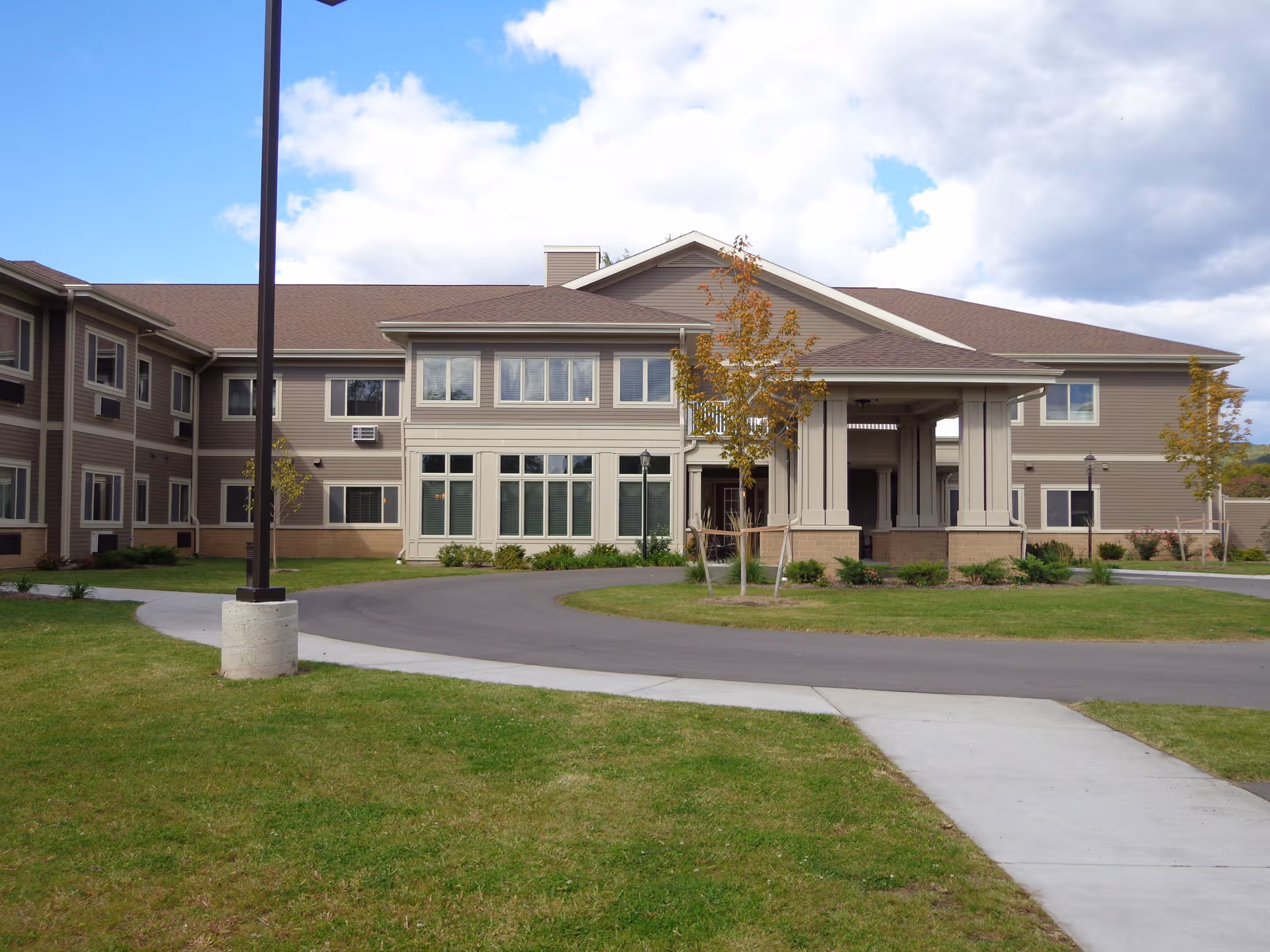 Exterior view of Hillview Terrace Assisted Living building with entrance and curved driveway.