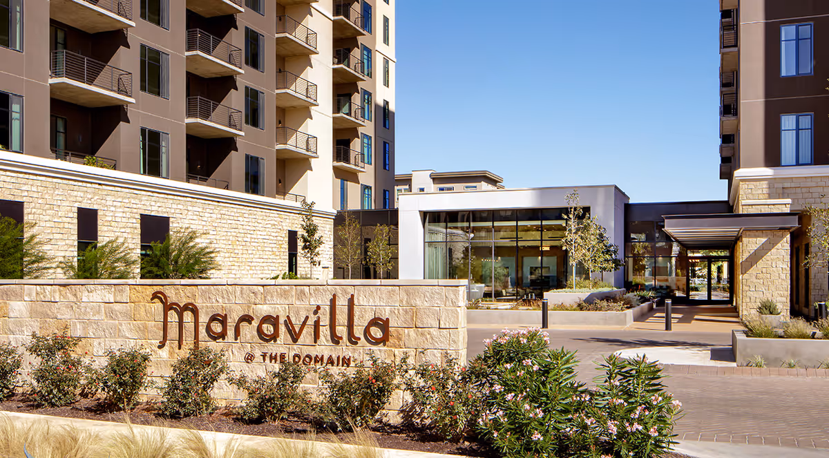 Exterior view of Maravilla at The Domain entrance with sign and landscaping