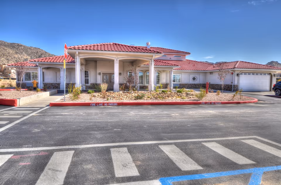 Single-story senior living entrance with red-tiled roof and landscaped front garden.