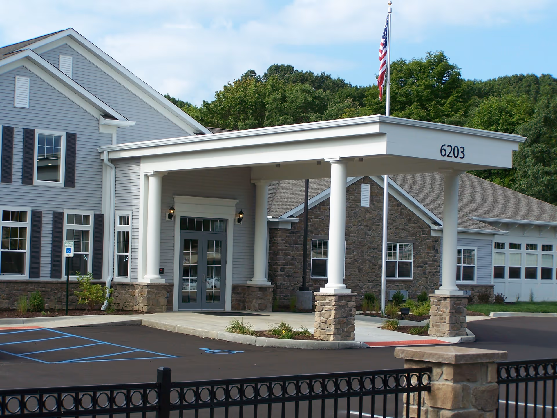 Exterior view of North Woods Village entrance with a covered drop-off area.