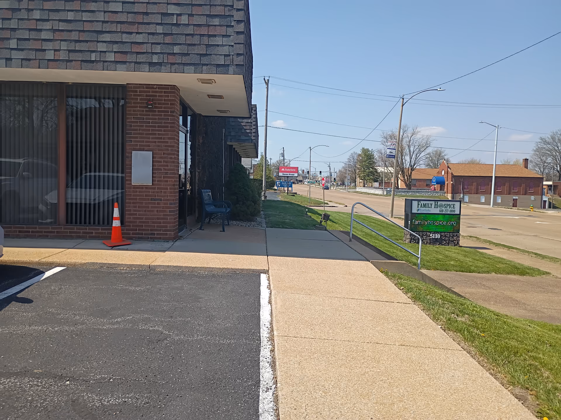 Exterior street view of a brick building with sidewalk and a Family Hospice sign