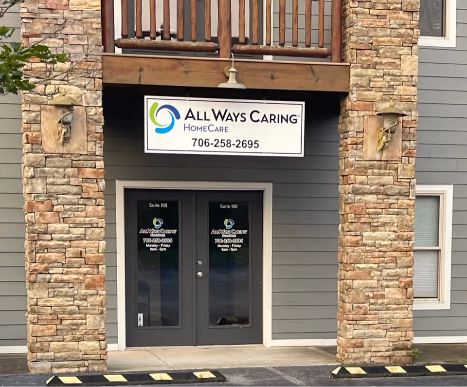 Front entrance of All Ways Caring HomeCare building with stone pillars and sign
