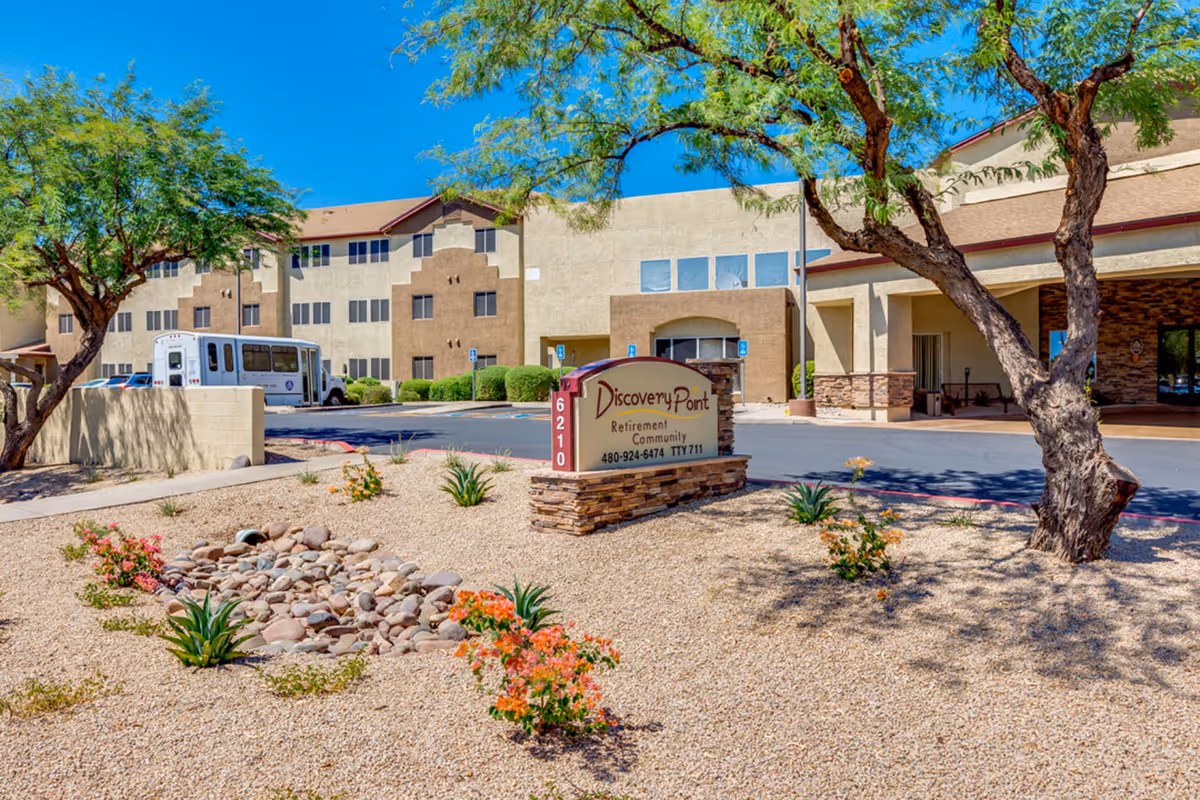 Exterior view of Discovery Point Retirement Community with landscaping and front sign.