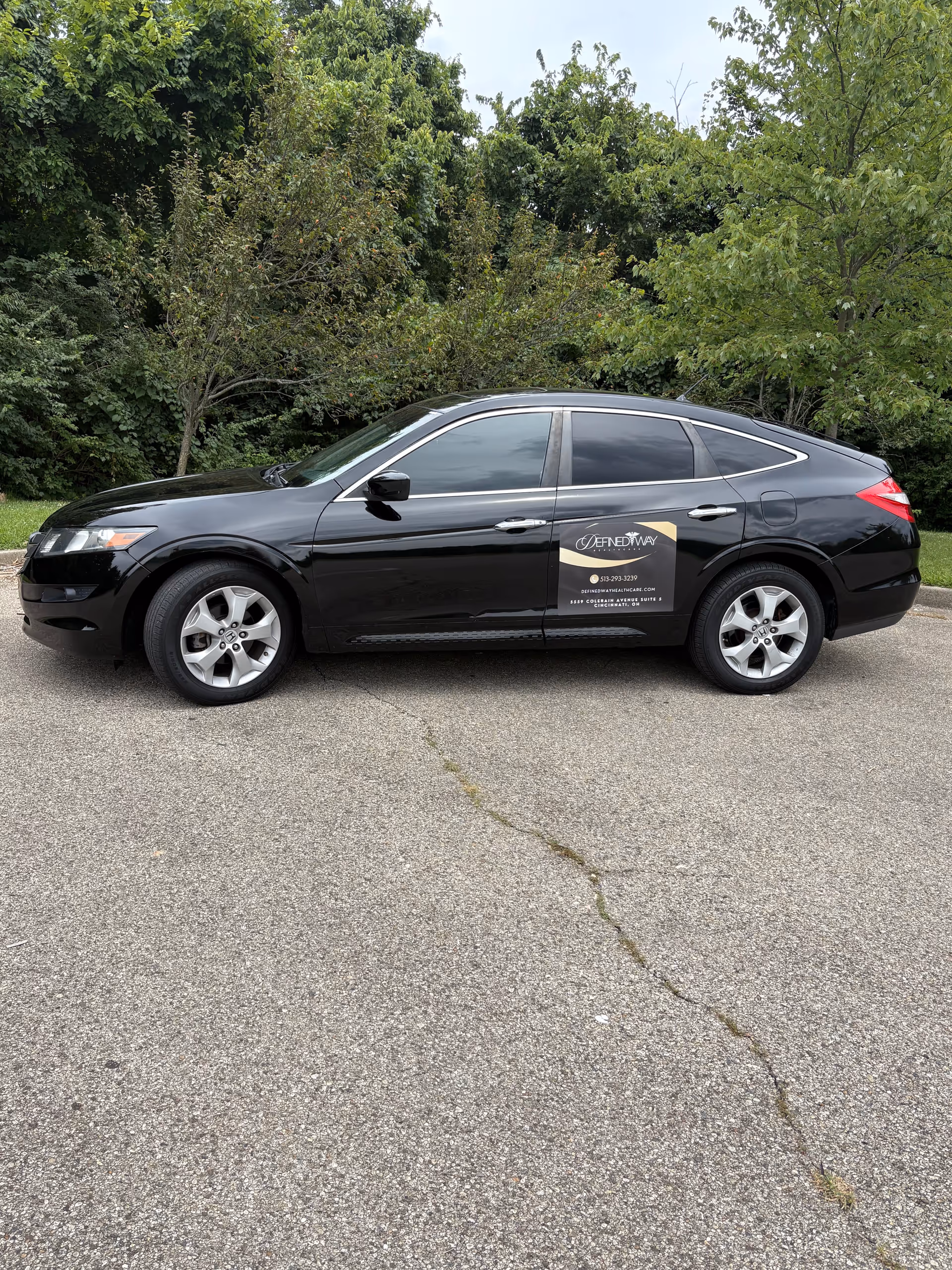Black sedan with Defined Way Healthcare logo parked in an outdoor lot.