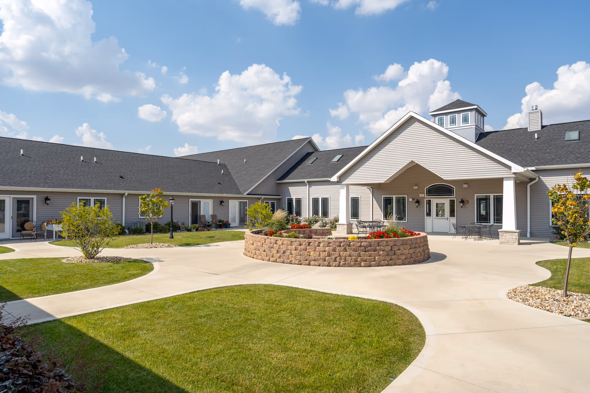 Exterior view of Gibson City Villas of Holly Brook with circular brick planter and entrance.