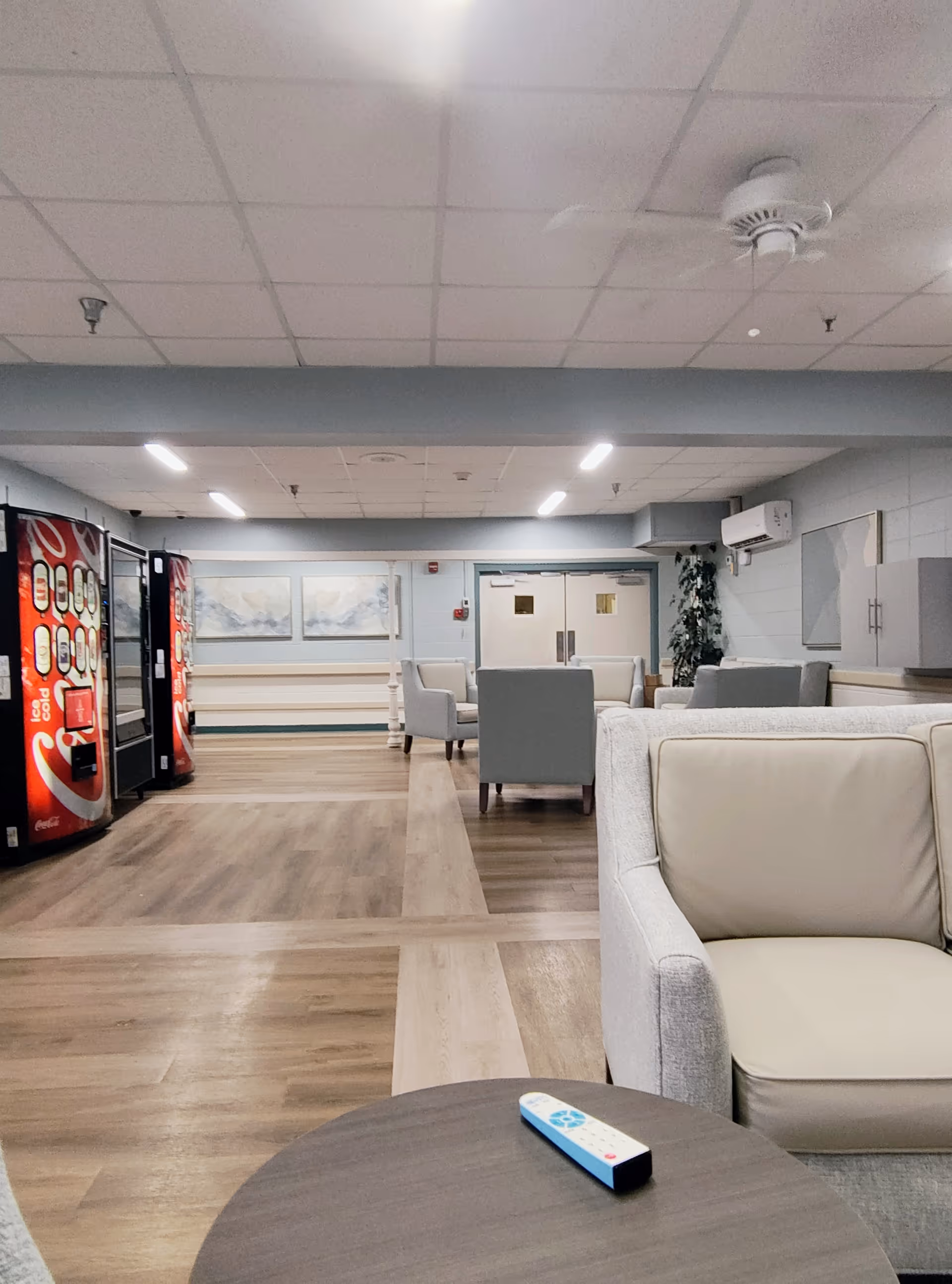 Spacious indoor lounge at Oak Haven Community Care Center with couches and vending machines.