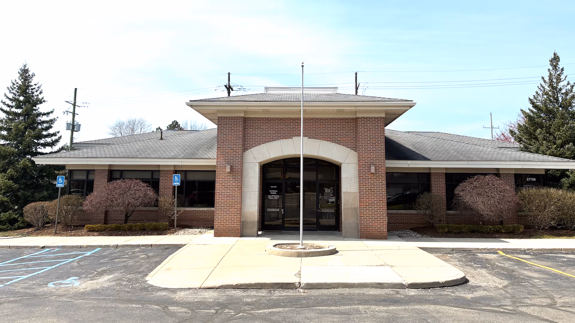 Luminary Health senior living facility entrance with brick facade and central glass doors.