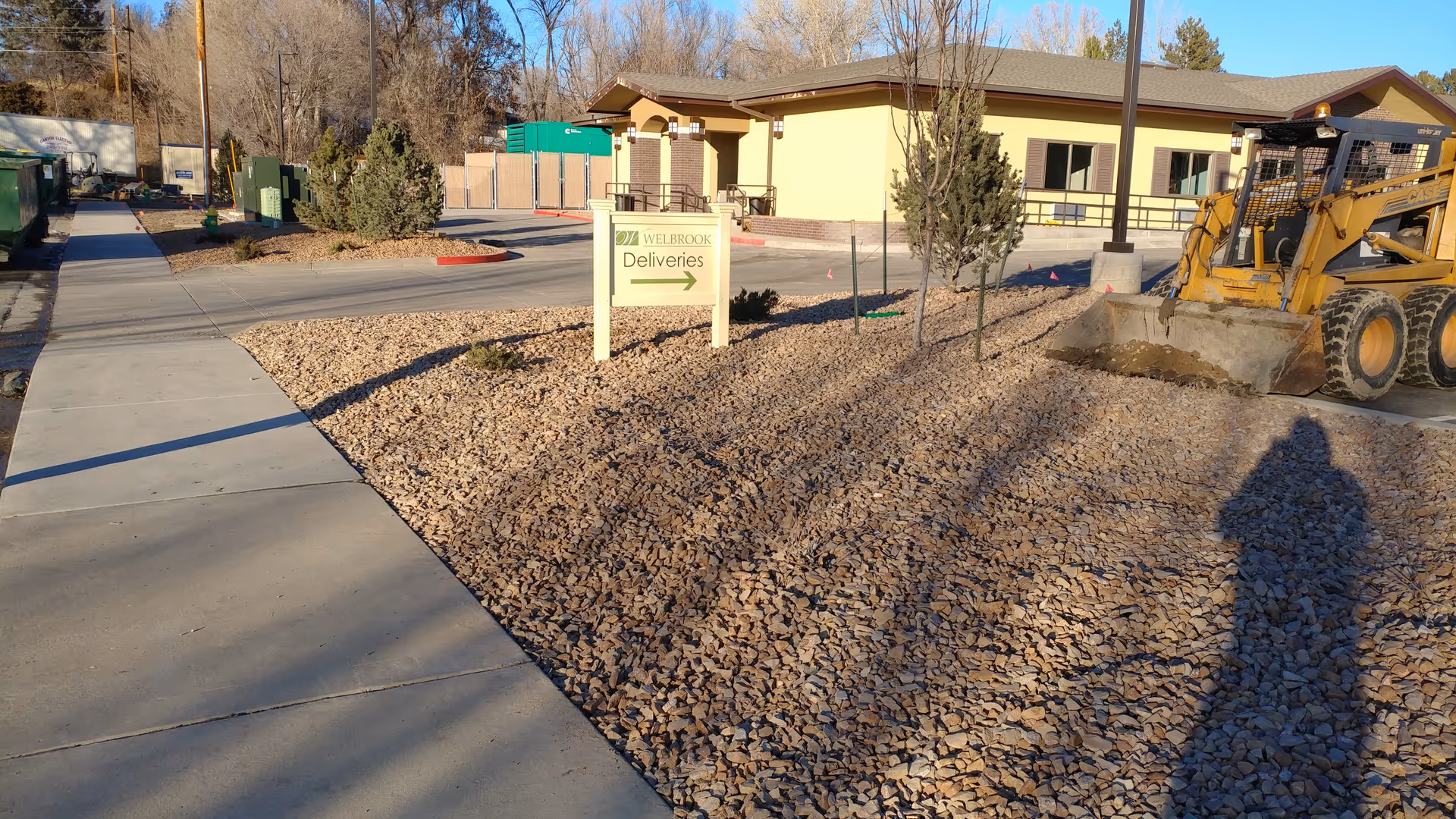 Exterior view of Welbrook Senior Living under construction with rocks and equipment.
