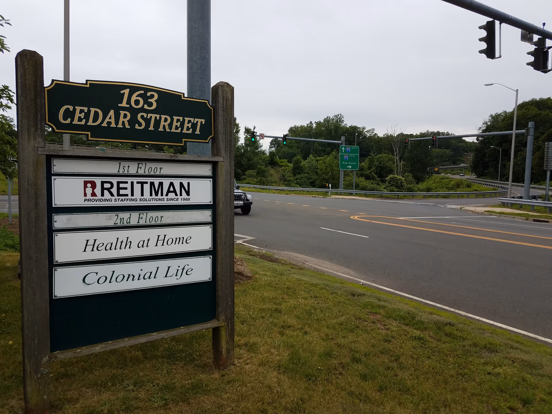 Roadside sign shows 163 Cedar Street with facility names.