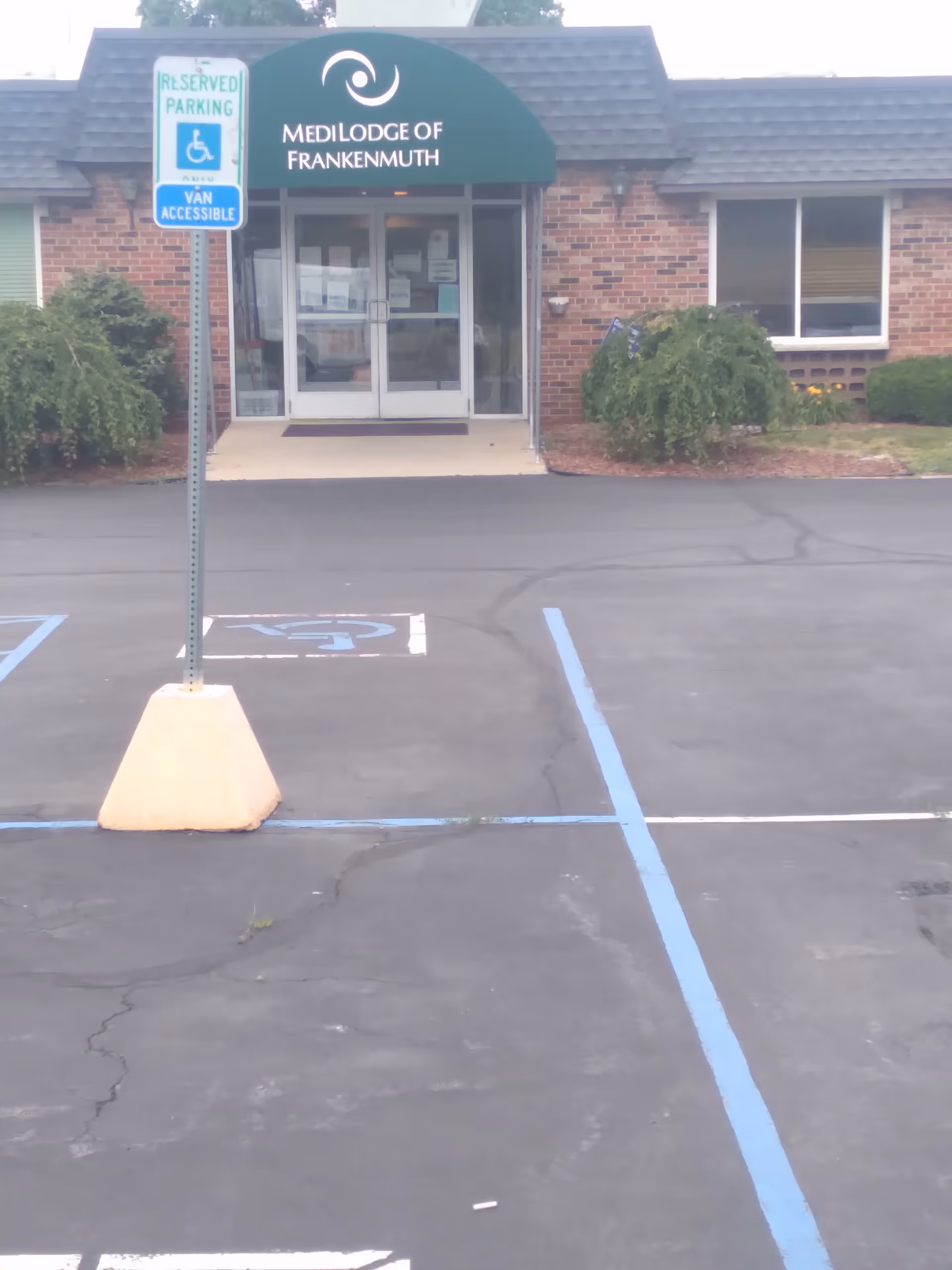 Exterior view of Medilodge of Frankenmuth, showing the entrance and a handicapped parking sign.