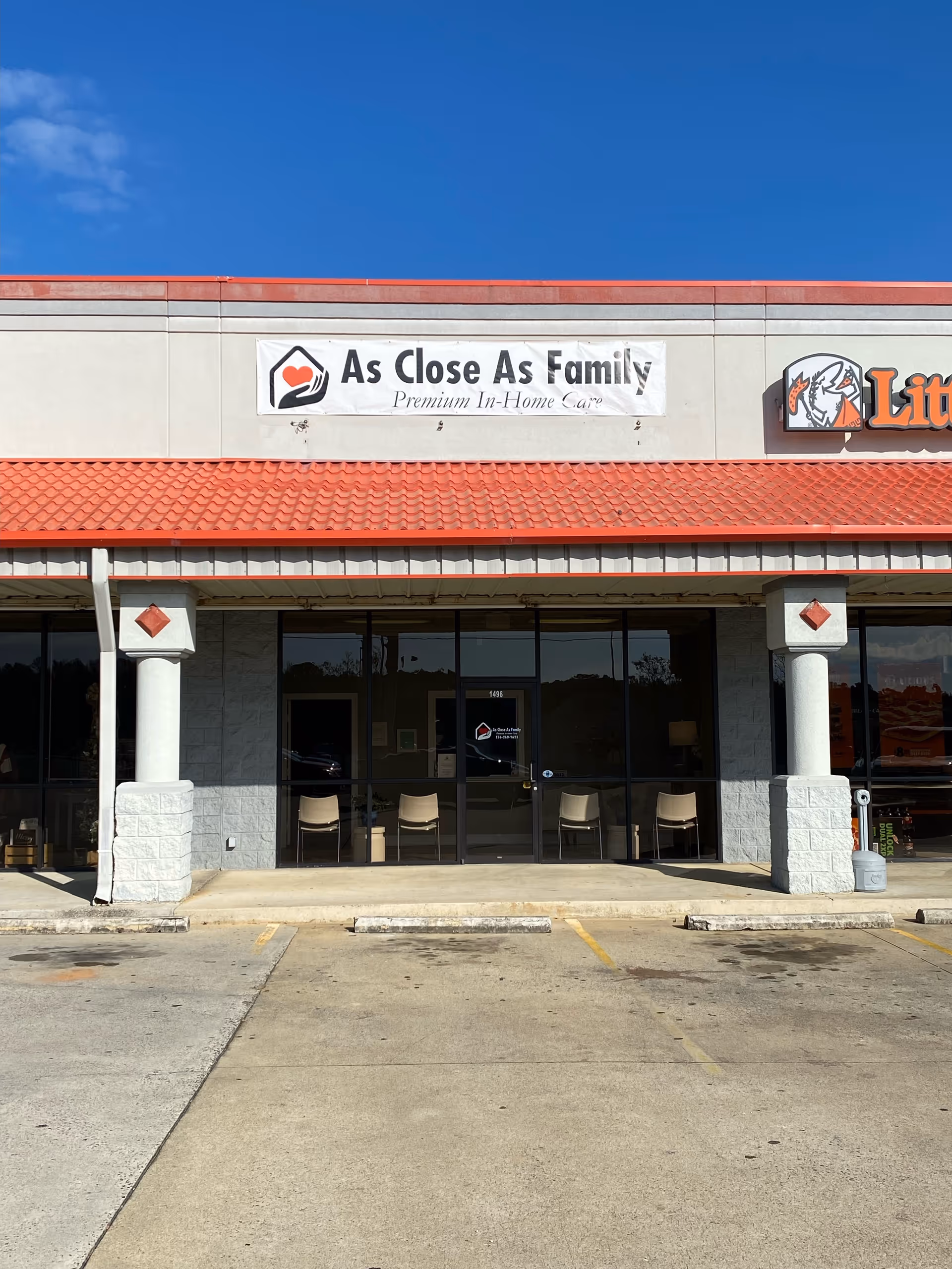 Exterior view of a storefront displaying 'As Close As Family' banner and glass doors.
