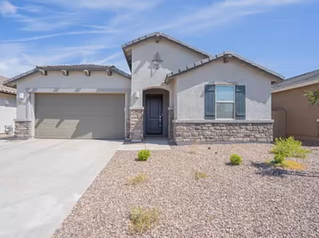 Front exterior of a single-story home-style facility with a two-car garage and desert landscaping.