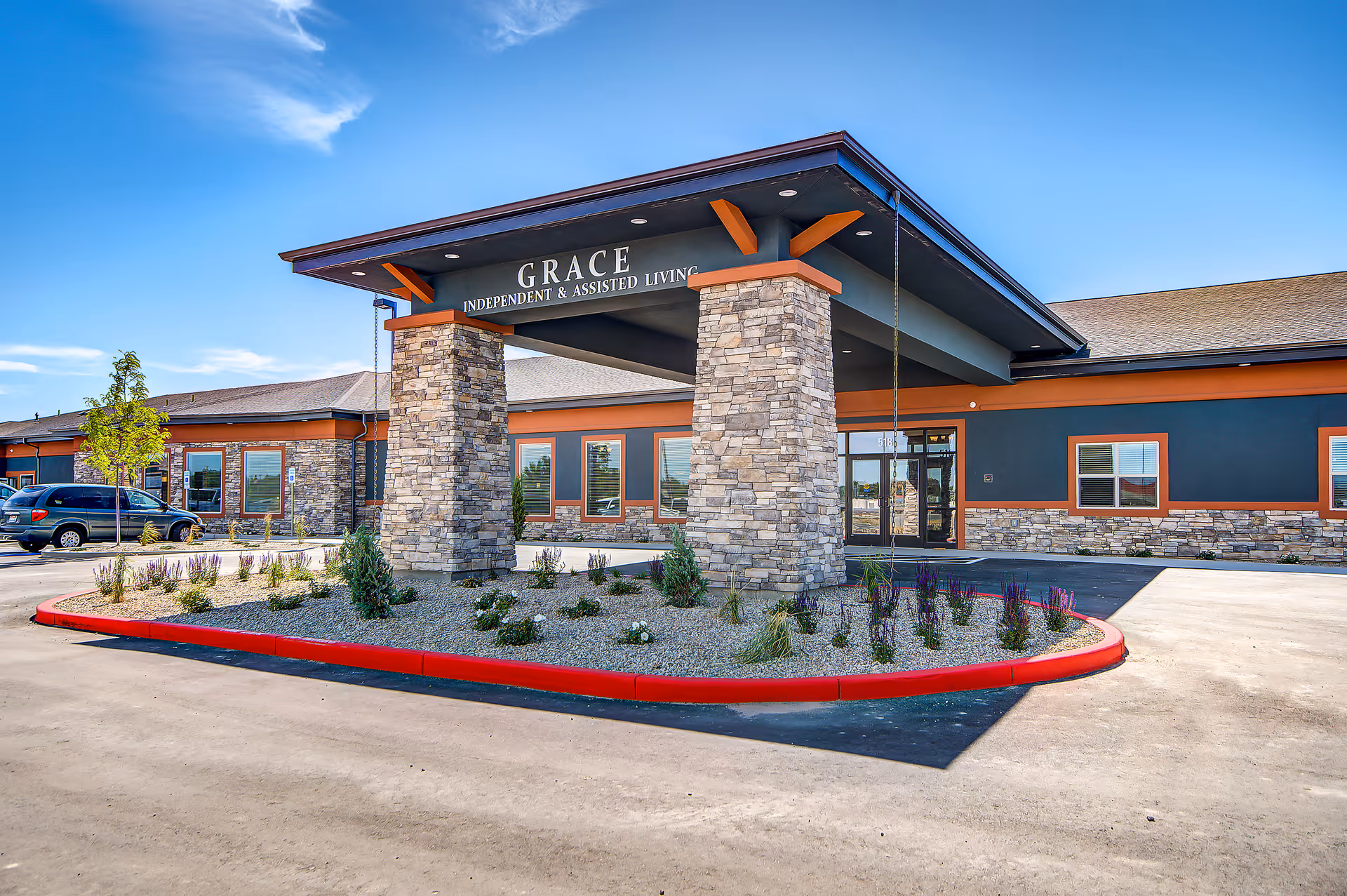Exterior view of Grace Independent & Assisted Living entrance with stone pillars and landscaping.