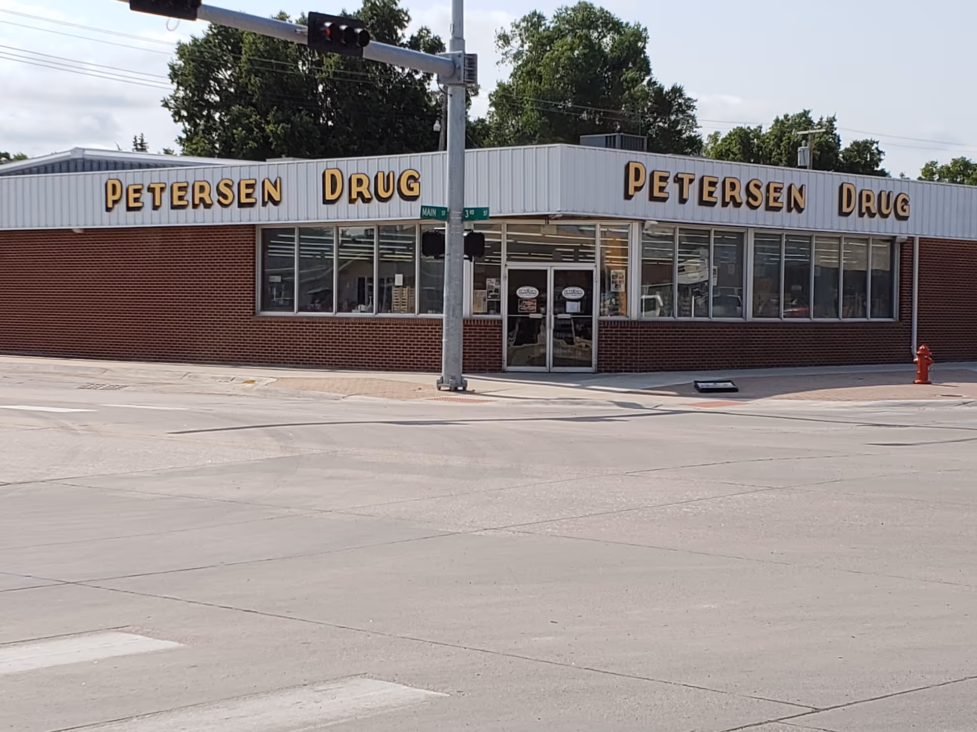 Exterior view of Petersen Drug store on a street corner with brick facade.