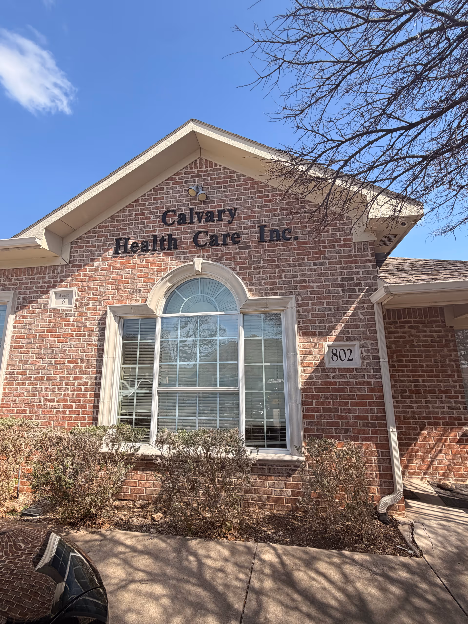 Exterior brick building with arched window and Calvary Health Care Inc sign