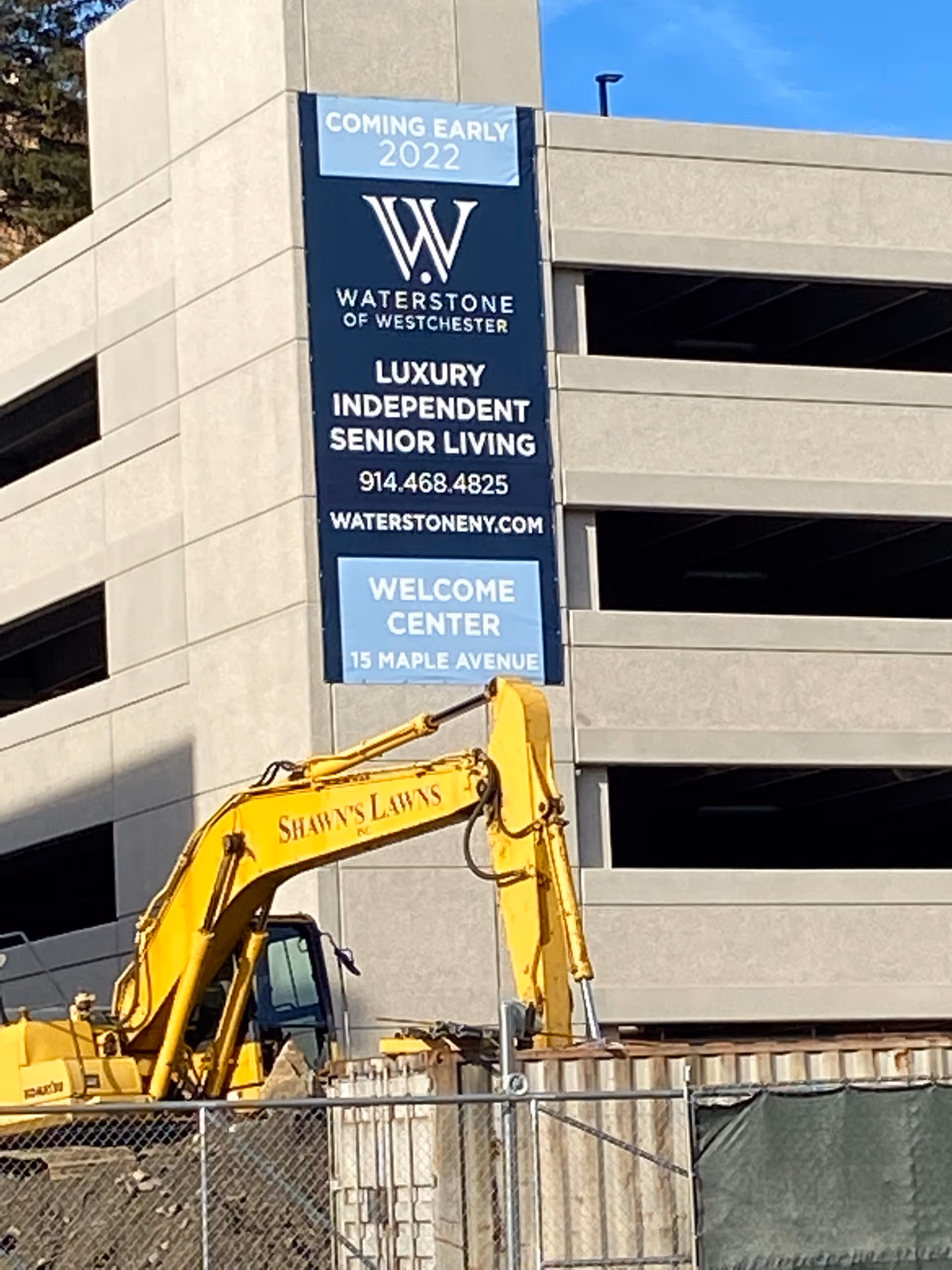 Waterstone of Westchester building exterior with sign and yellow construction equipment in front.