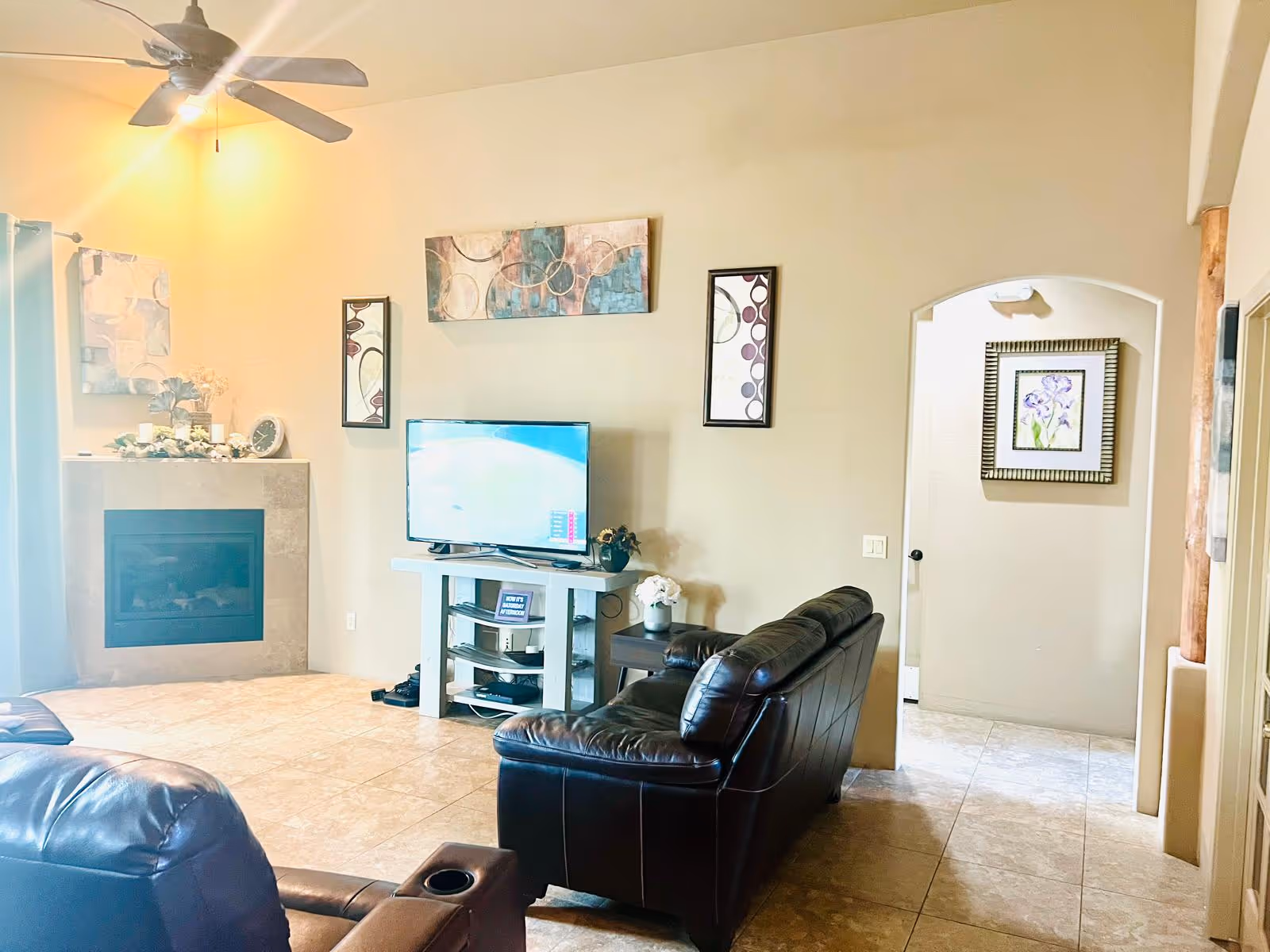 Living room in Fountain Hills Manor Assisted Living with leather seating, fireplace, and TV.