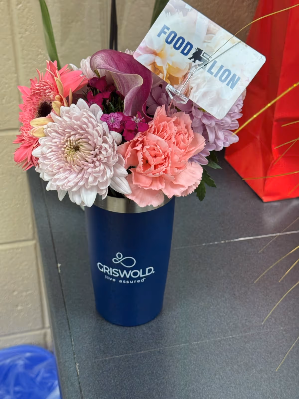 Flower bouquet in a blue Griswold vase on a dark countertop indoors.