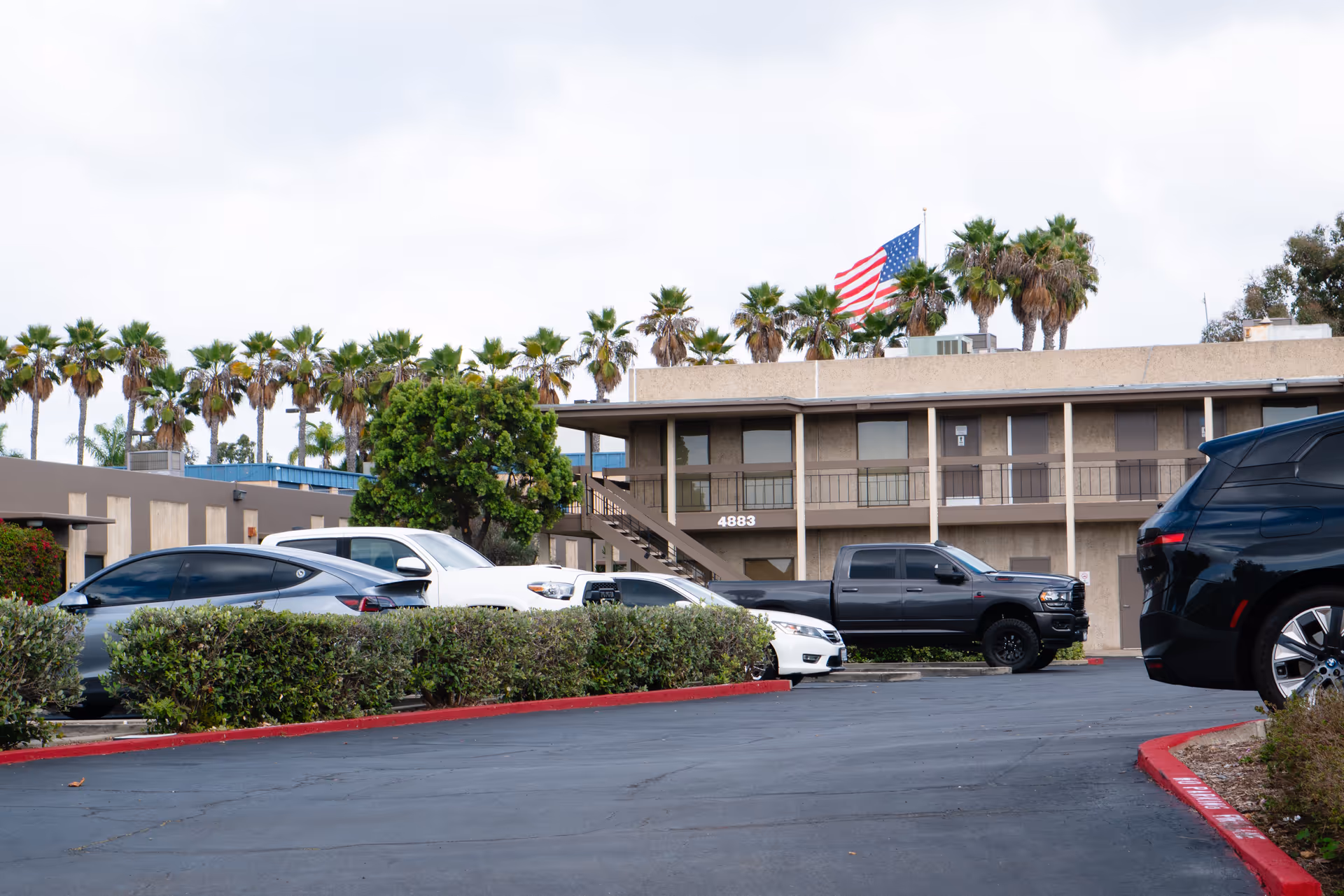 Parking lot in front of Griswold Home Care La Jolla building with palm trees.