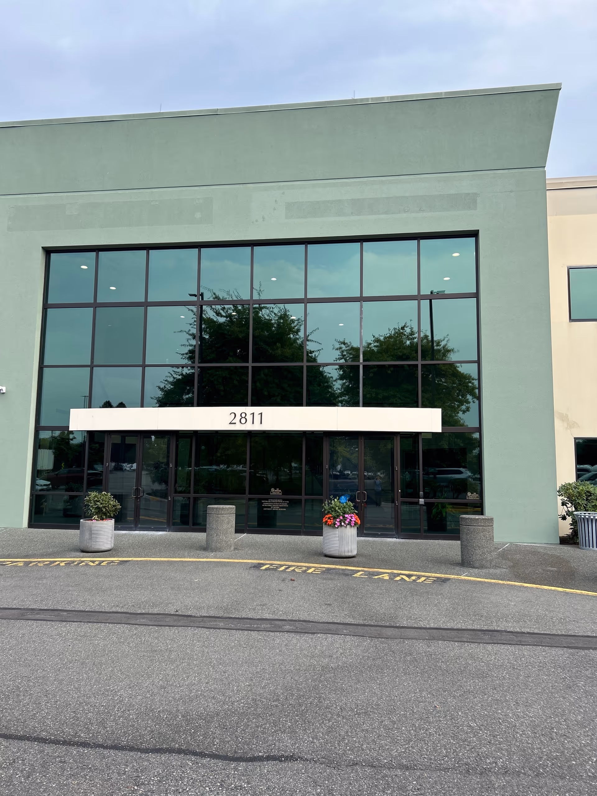 Exterior view of Providence at Home with Compassus entrance with glass doors and planters.