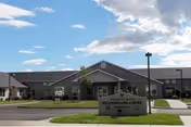 Exterior of Assisted Living at the Colonnade with a manicured lawn and stone front sign.