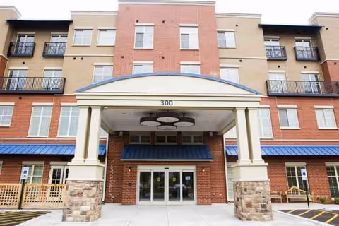 Exterior view of Lombard Place Assisted Living entrance with brick façade and columns.