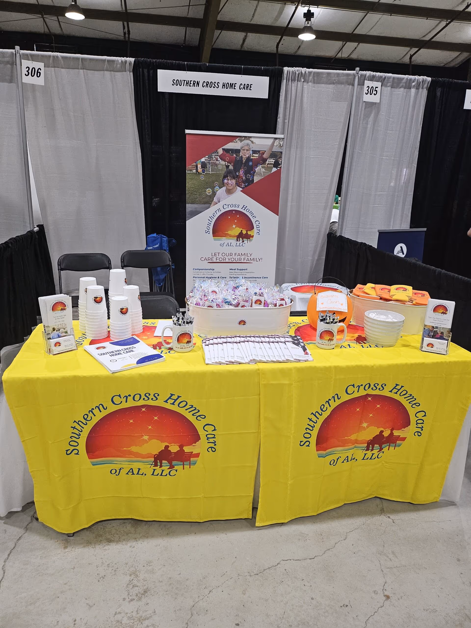 Indoor convention booth for Southern Cross Home Care with yellow tablecloths and brochures.