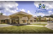 Exterior view of a health care center with a covered entry and manicured lawn.