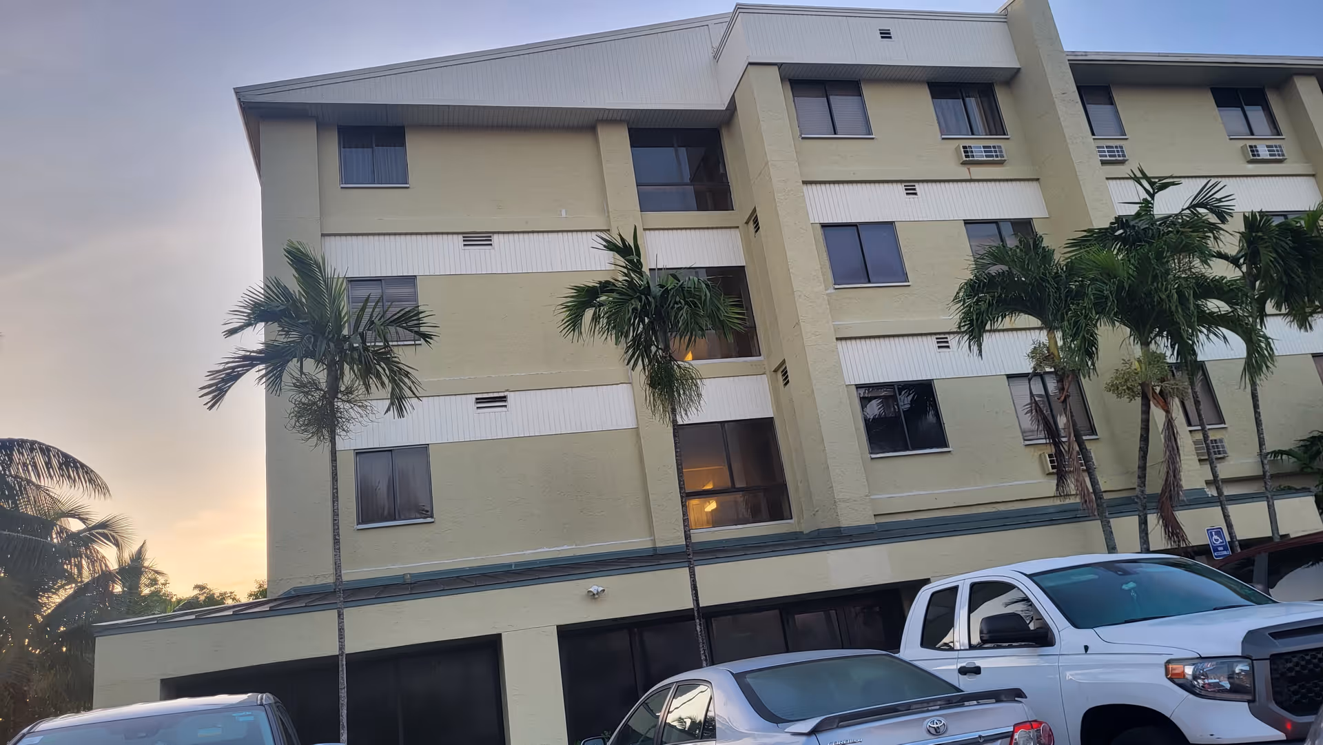 Exterior view of Waterford Rehab and Nursing Center, multi-story facility with palm trees and parked cars.