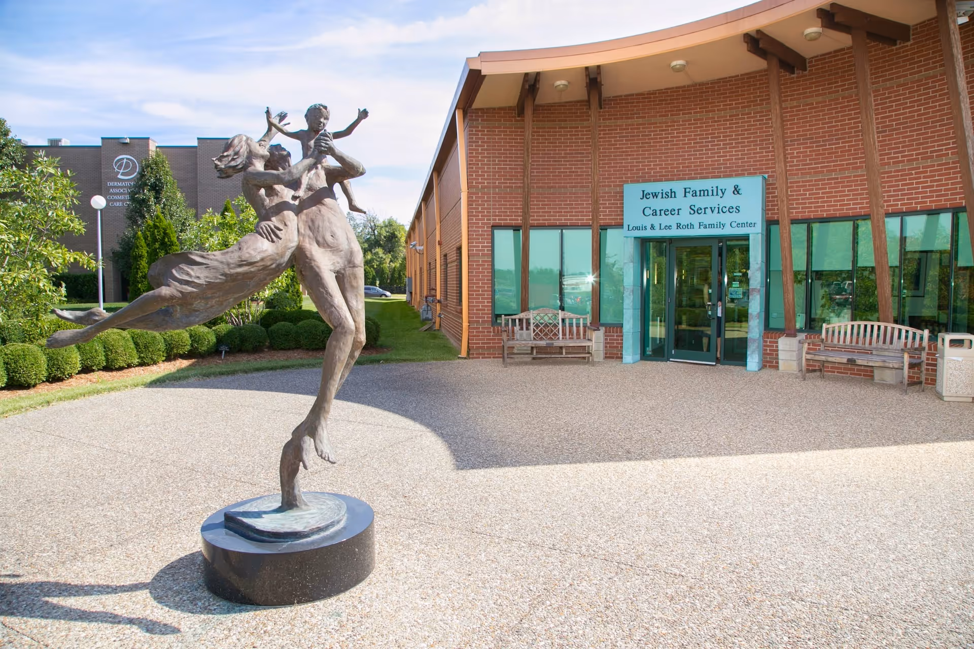 Bronze sculpture of a dancer in front of brick building labeled Jewish Family & Career Services.
