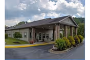 Exterior view of The Waters of Roan Highlands entrance with landscaped shrubs and driveway.