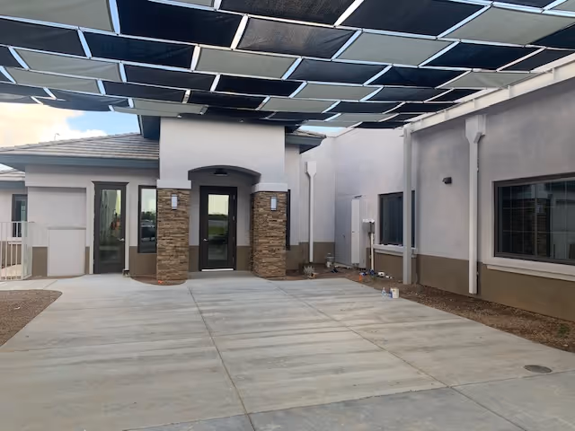 Exterior view of Park Senior Villas entrance with a shaded canopied walkway.