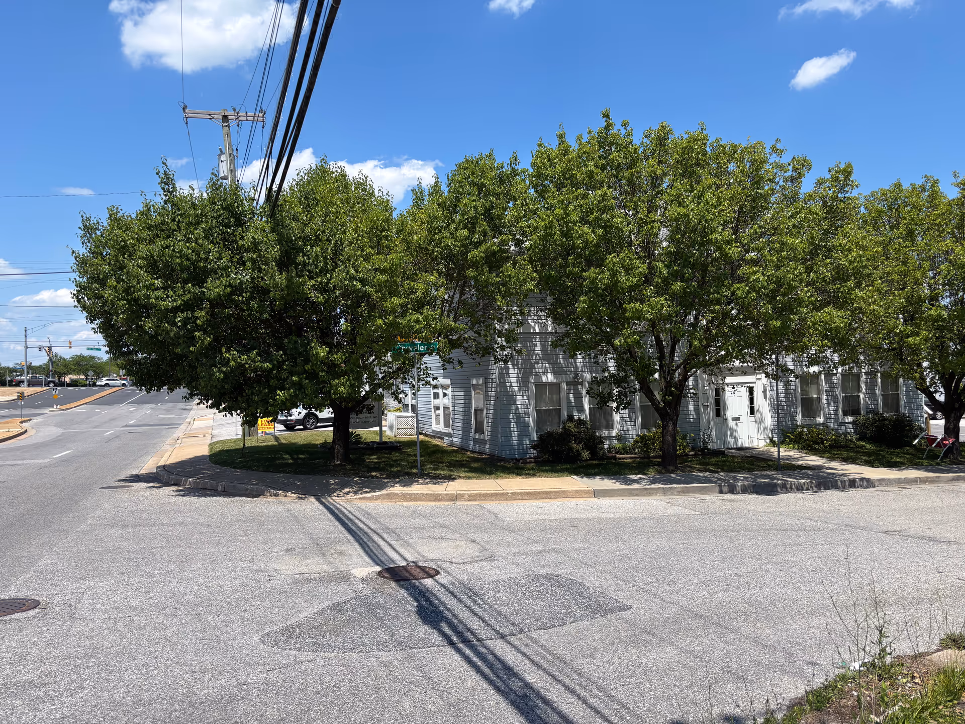 Exterior view of a building with trees along a street corner.