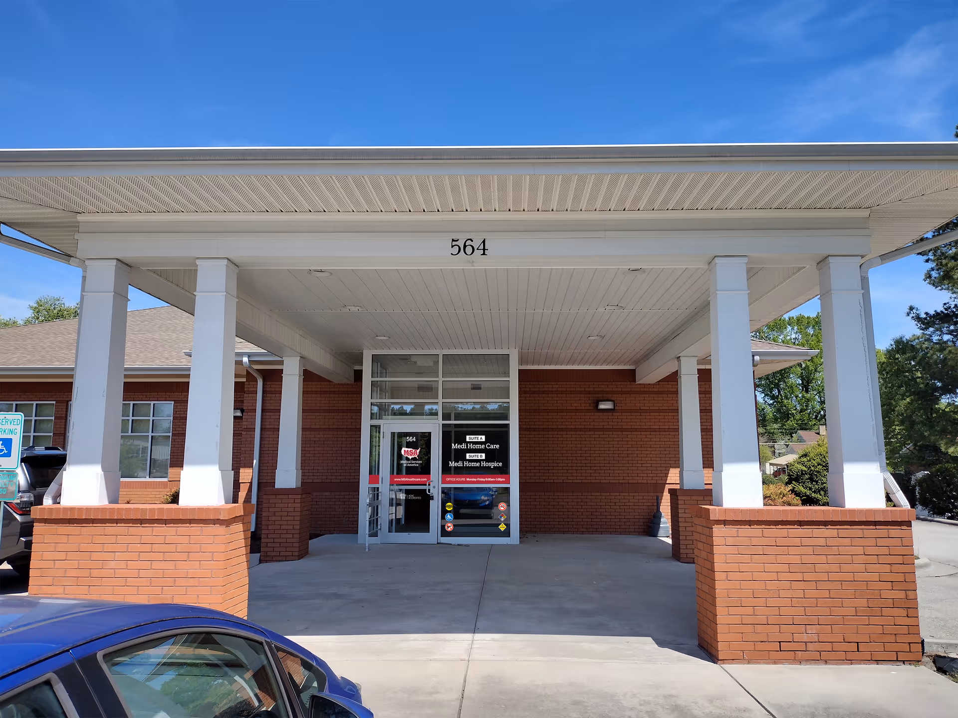 Front entrance of a brick senior care facility with a covered drop-off area.