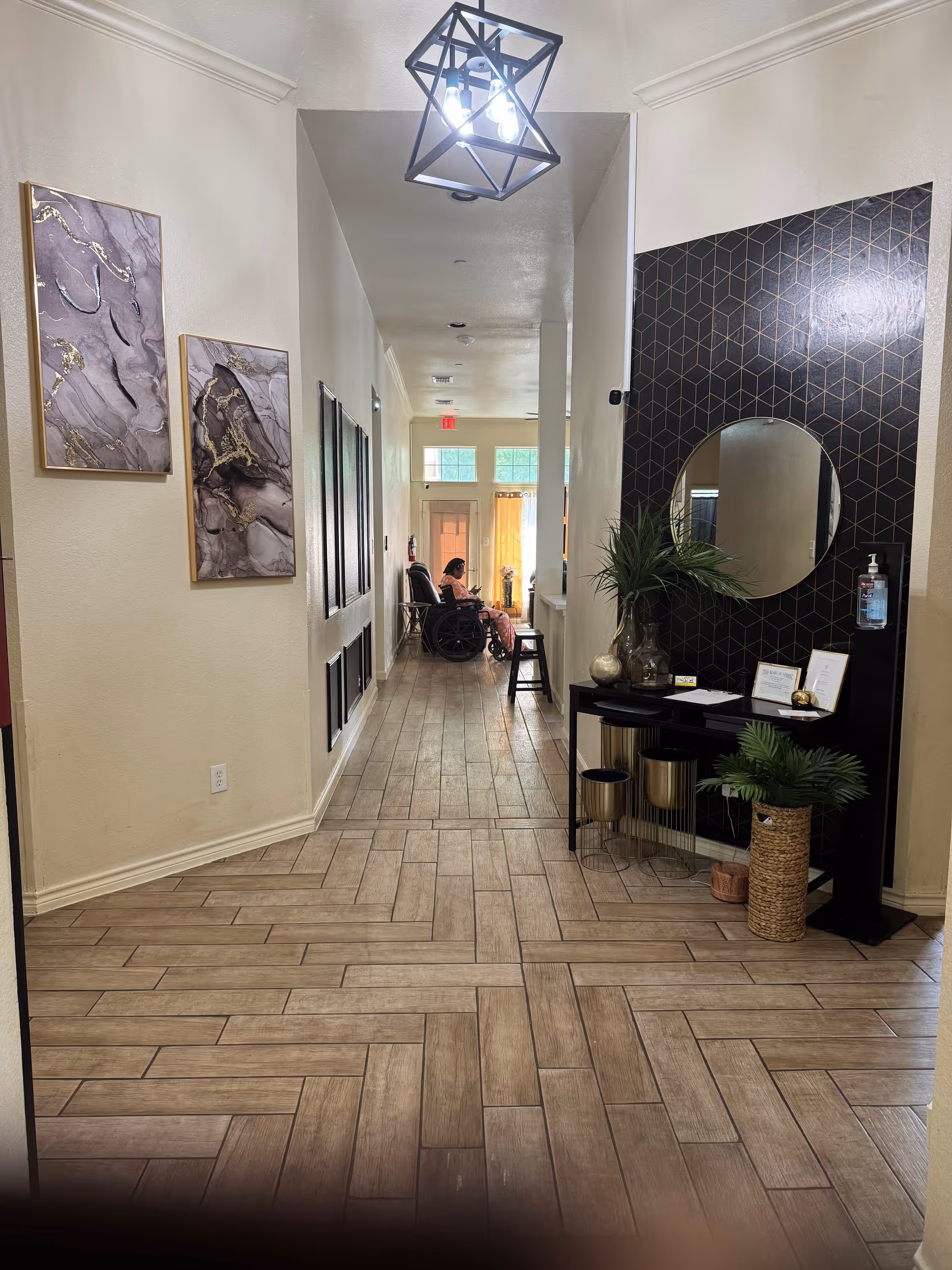 Polished hallway in an accessible living facility with artwork, a console table, and residents.