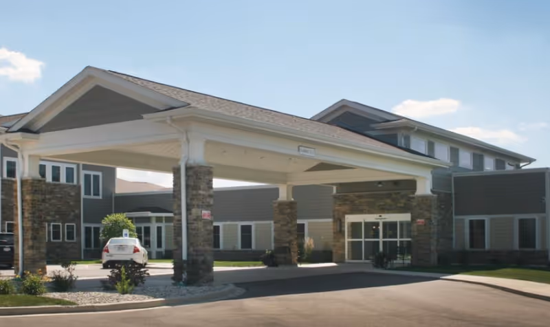 Exterior view of Brittania Garden Personal Care with a covered entrance and stone columns.