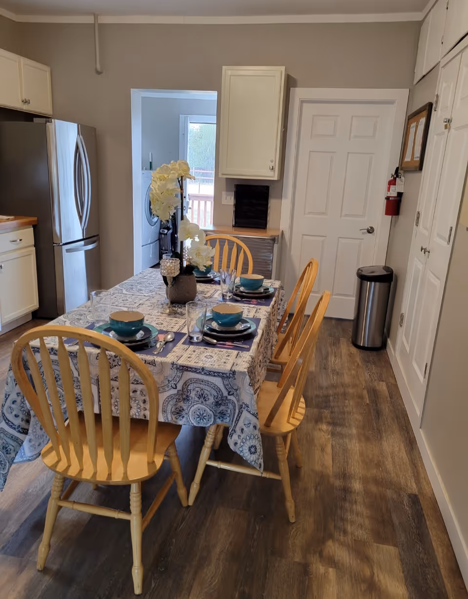 Dining table set with dishes and a floral centerpiece in a kitchen-style dining area.