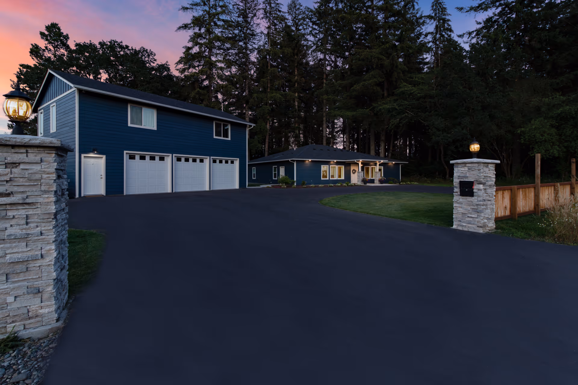 Exterior view of blue residential facility with long driveway and trees.