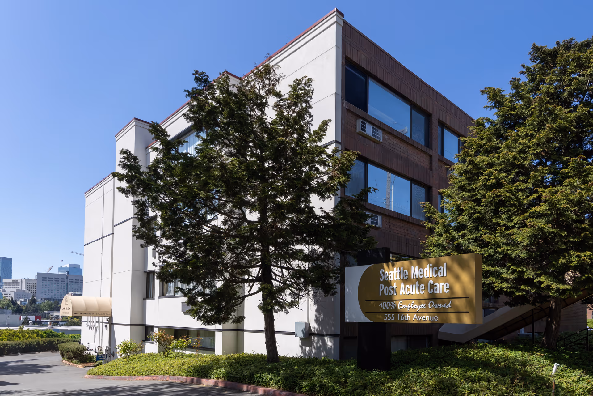 Three-story building exterior with large windows and a Seattle Medical Post Acute Care sign.