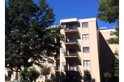 Exterior view of Covenant Towers, a beige multi-story senior living building with balconies.