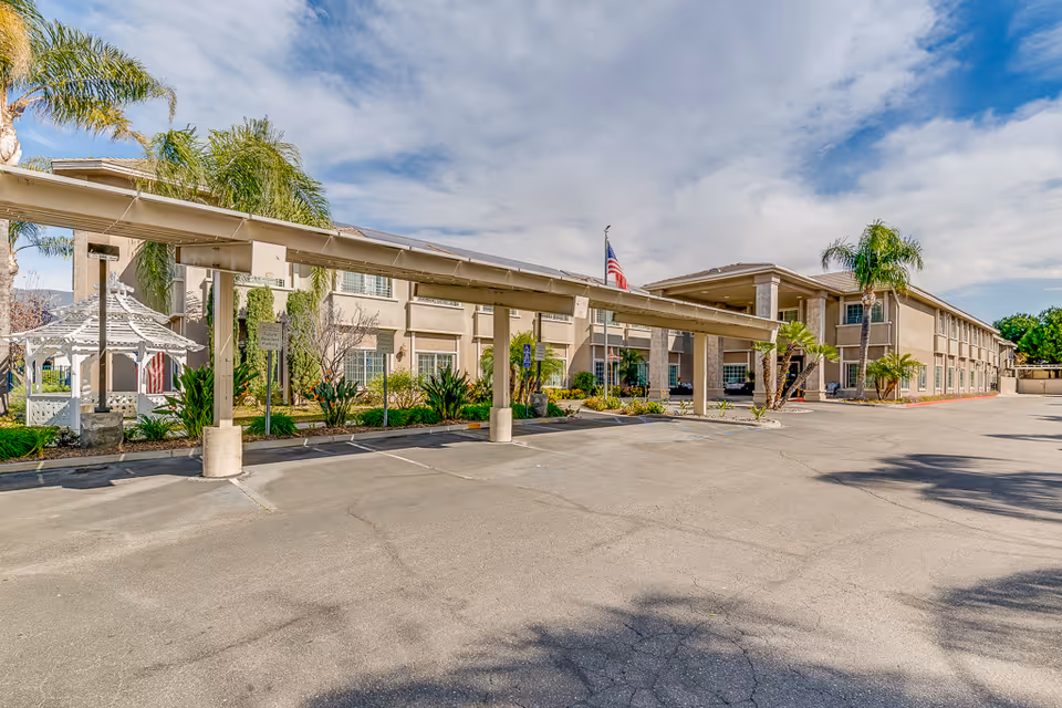 Exterior view of Villas at San Bernardino building with covered walkway and palm trees.
