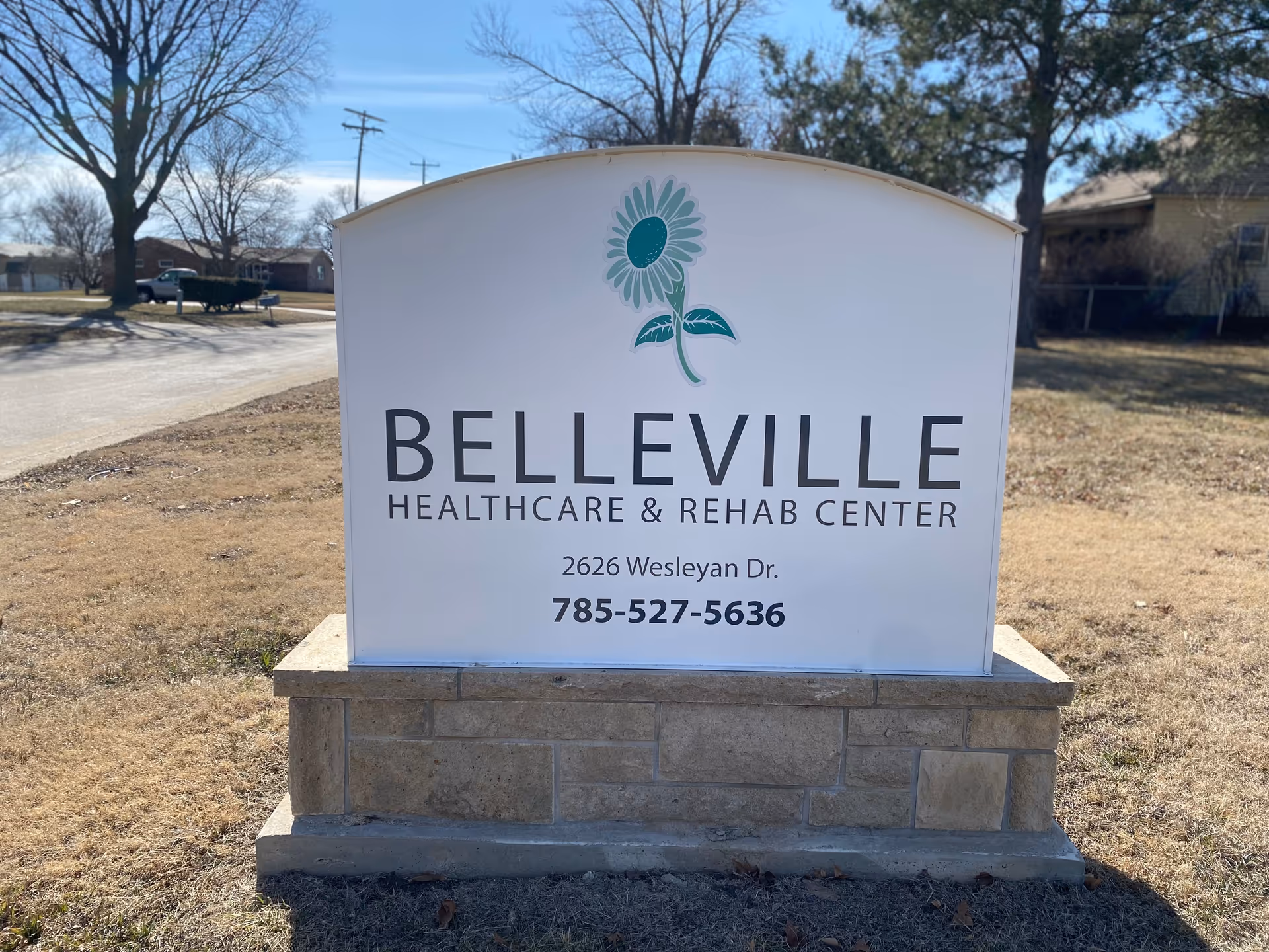 A large sign reads Belleville Health Care Center with a sunflower logo on a stone base.