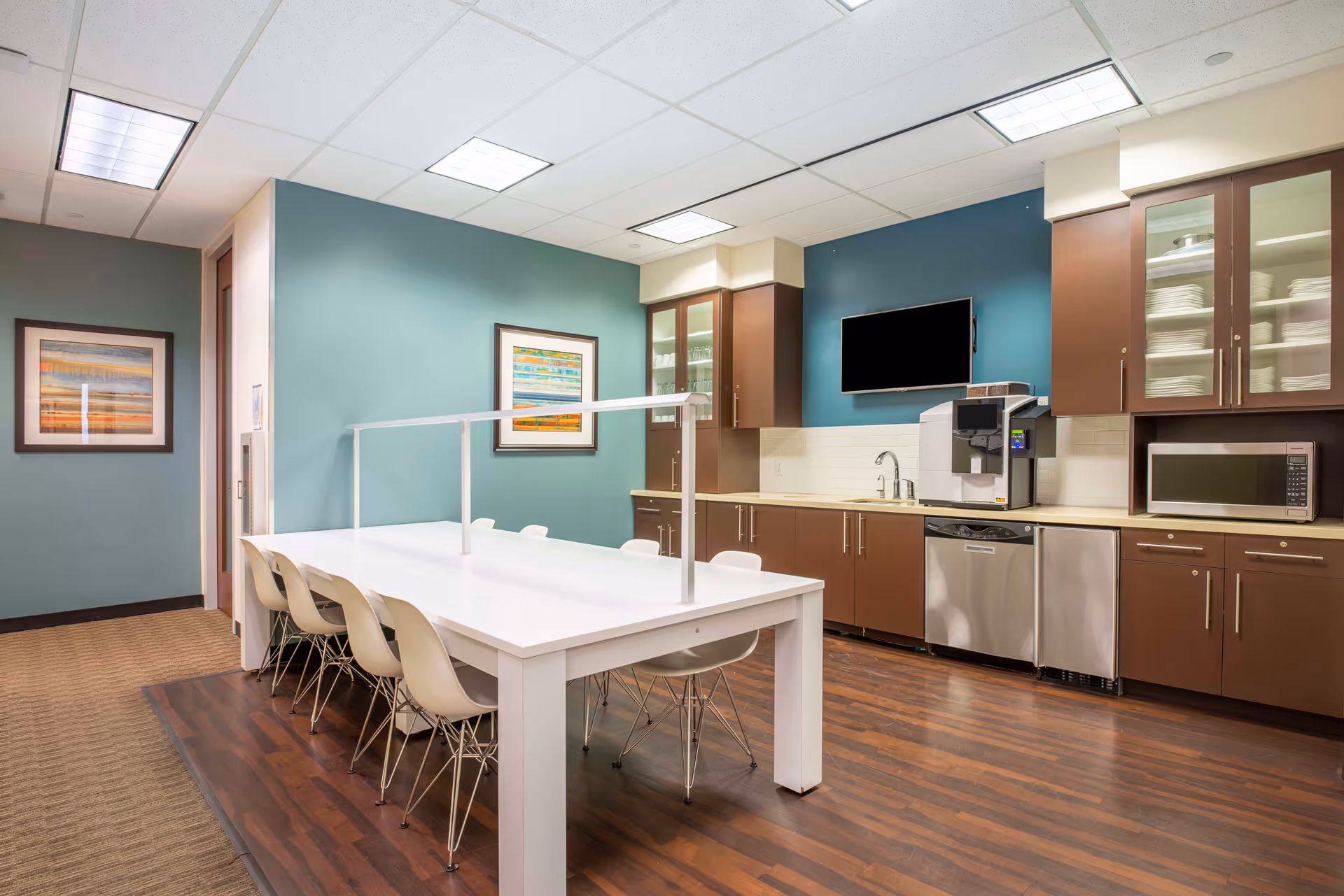 Bright kitchen and dining area with a long white table and chairs.