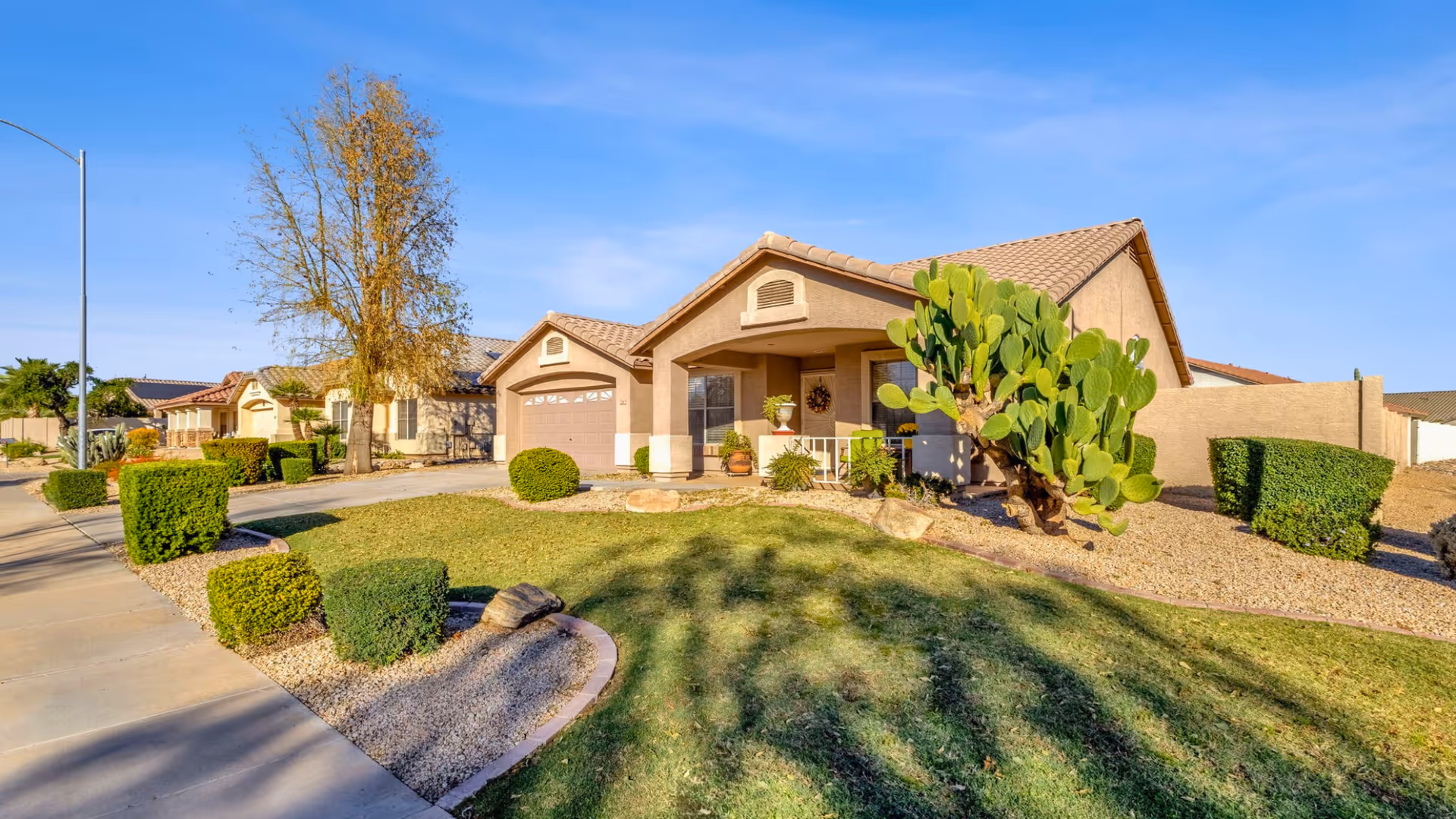 A single-story beige villa-style senior living facility front exterior with desert landscaping.