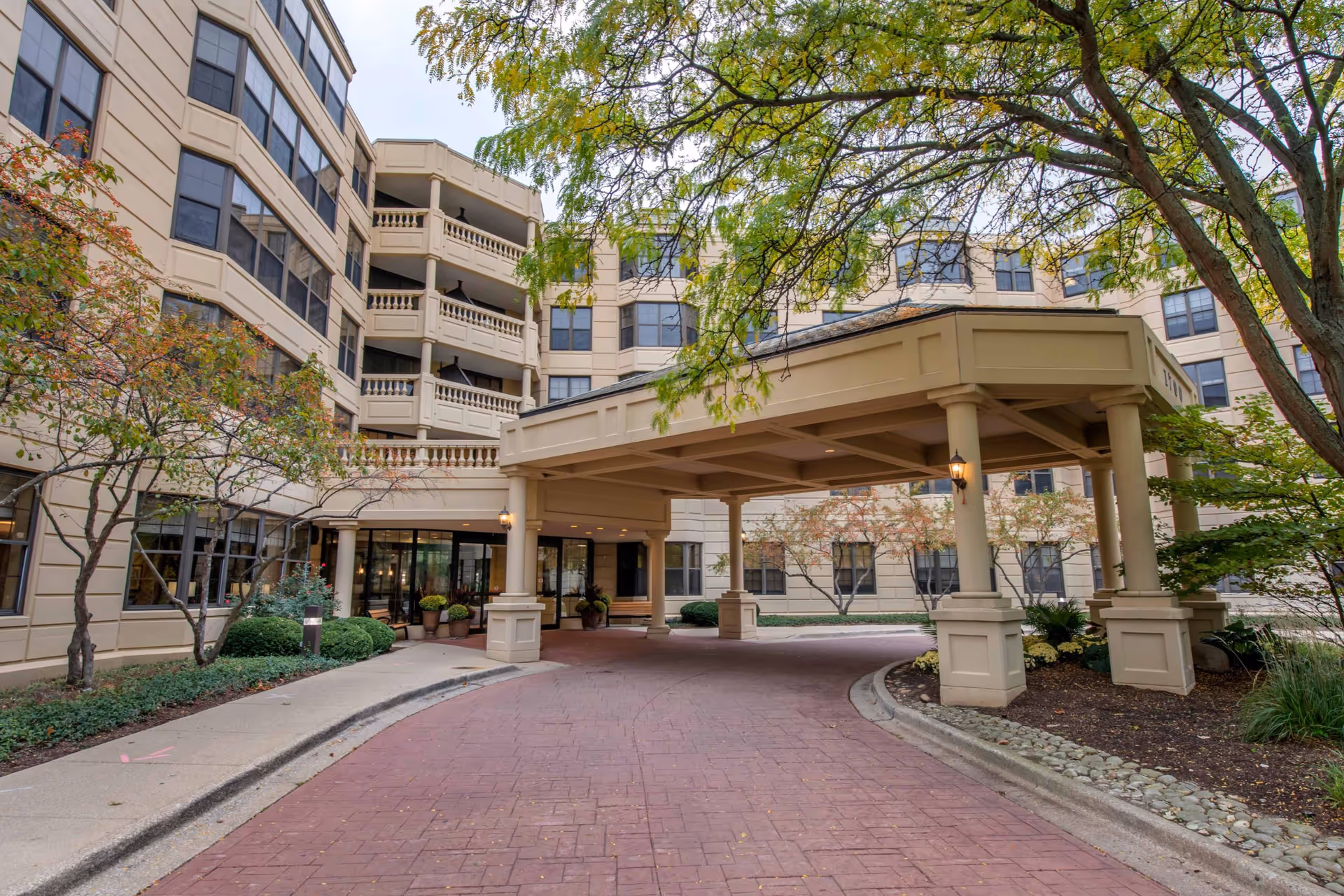 Exterior view of The Commons at Lisle Creek Estates with a porte-cochère entrance and trees